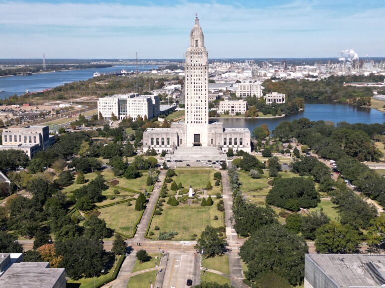 Drone view of the Louisiana State Capitol in Baton Rouge, Louisiana over green parks