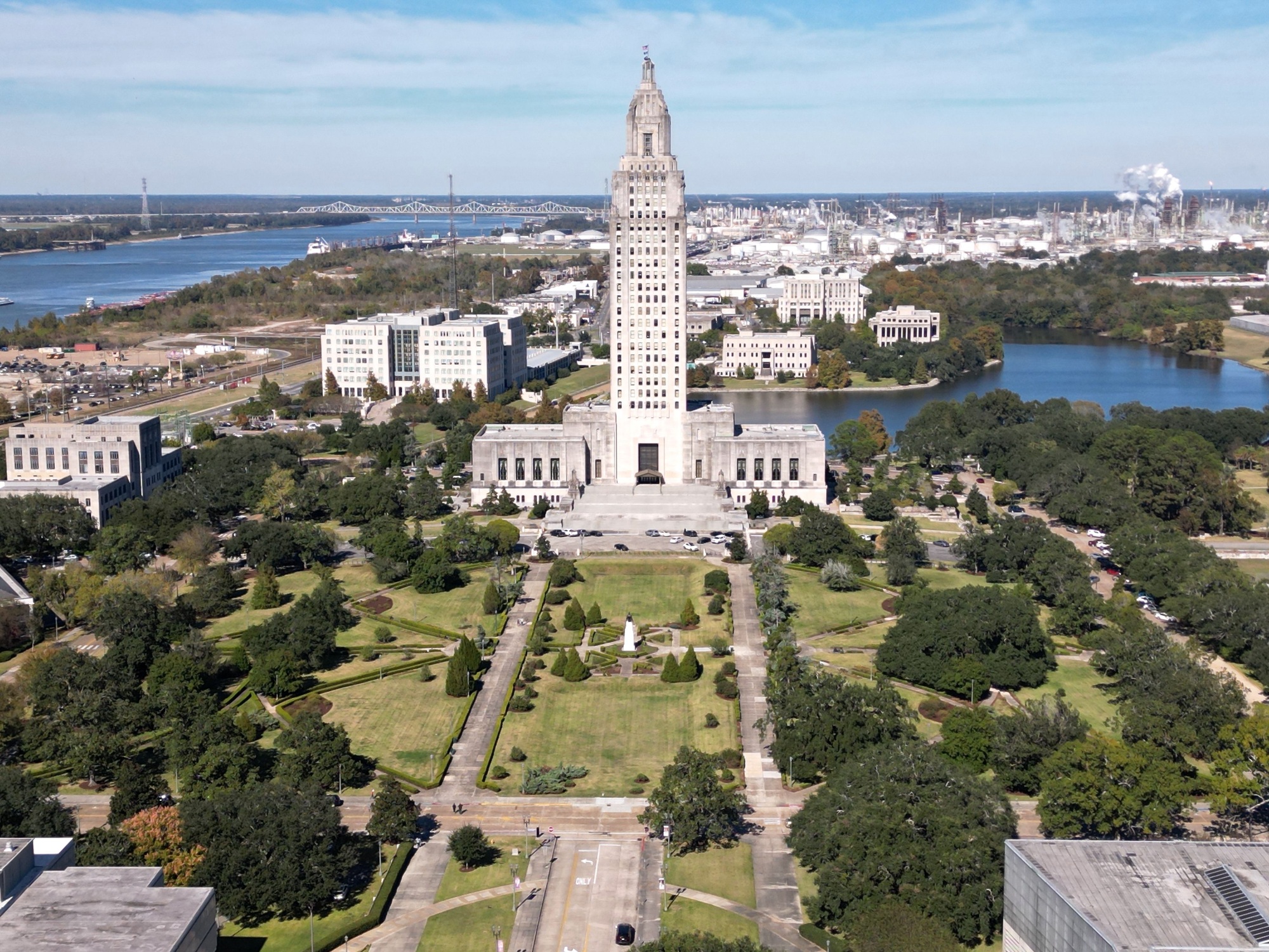 Drone view of the Louisiana State Capitol in Baton Rouge, Louisiana over green parks